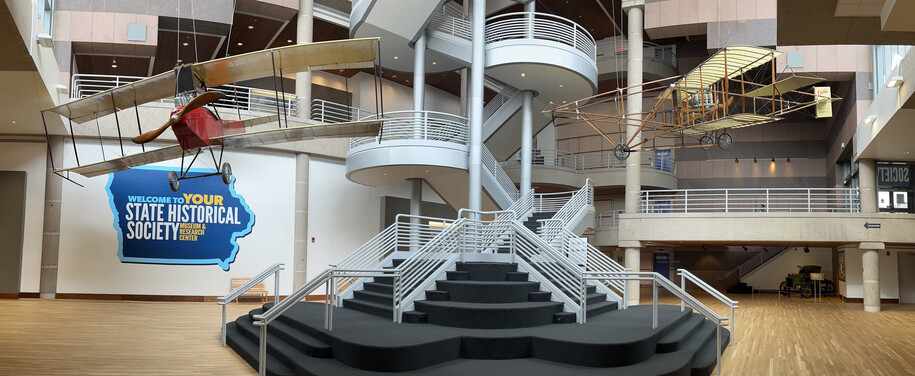 Atrium of the State Historical Building with two planes hanging from the ceiling